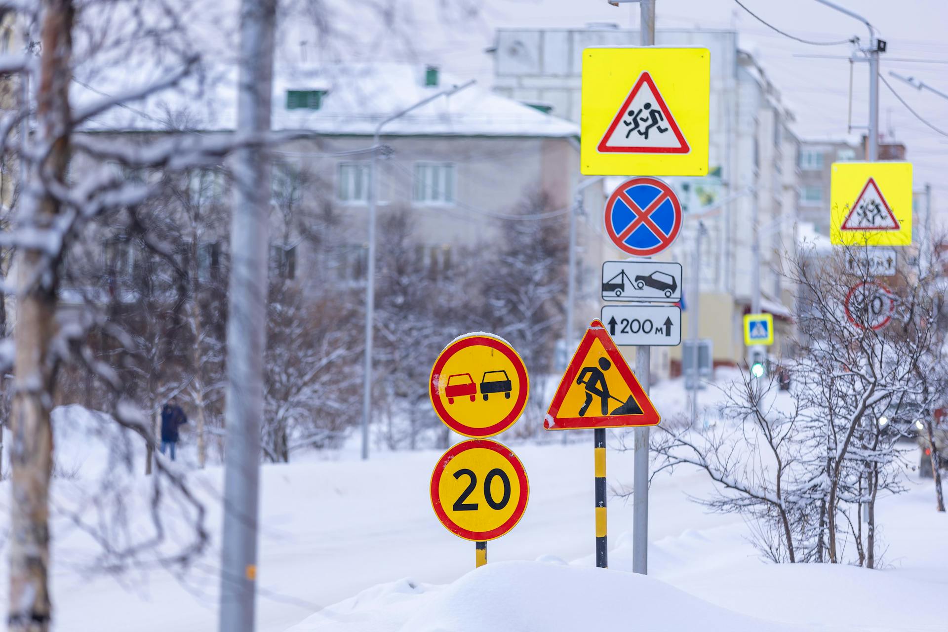 Colorful traffic signs in a snowy city street during winter.