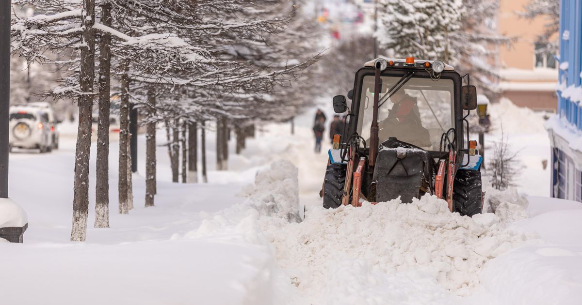 Schneepflug räumt eine Straße in einer städtischen Umgebung, Symbolbild für Räumtechnik im Winterdienst