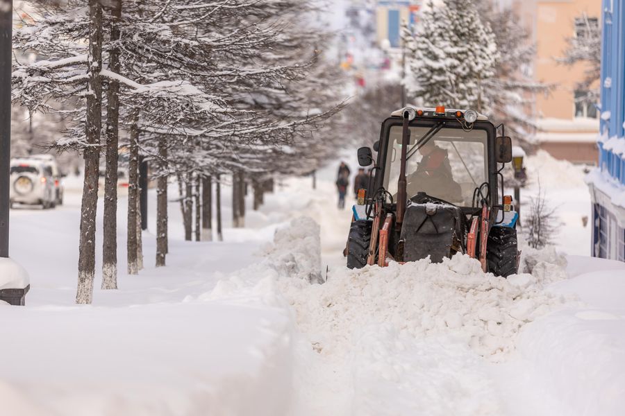 Sidewalk machine clearing snow from a city sidewalk