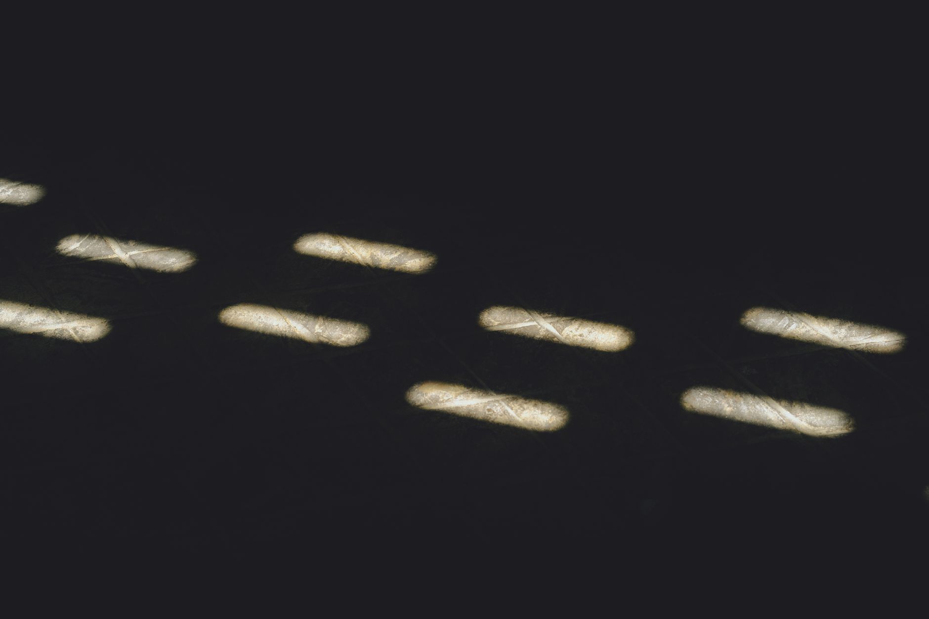 Abstract image of light patterns resembling morse code on a dark background.