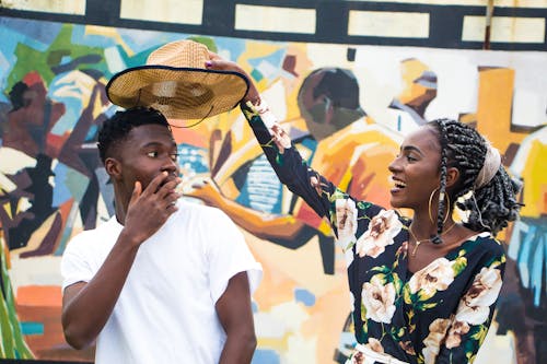 Woman Holding Man's Hat