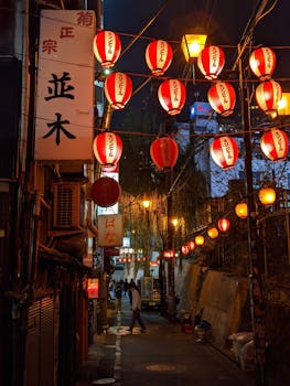 A vibrant night scene of a Tokyo alleyway illuminated by traditional red paper lanterns.