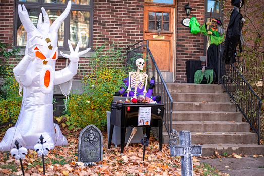 Spooky Halloween decorations featuring an inflatable ghost and skeleton on a porch.