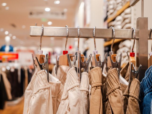 Close-up of garments hanging in a retail store, representing product sourcing