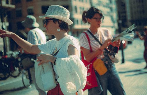 Free Two women enjoy a sunny day in the city, pointing and navigating with a map. Stock Photo