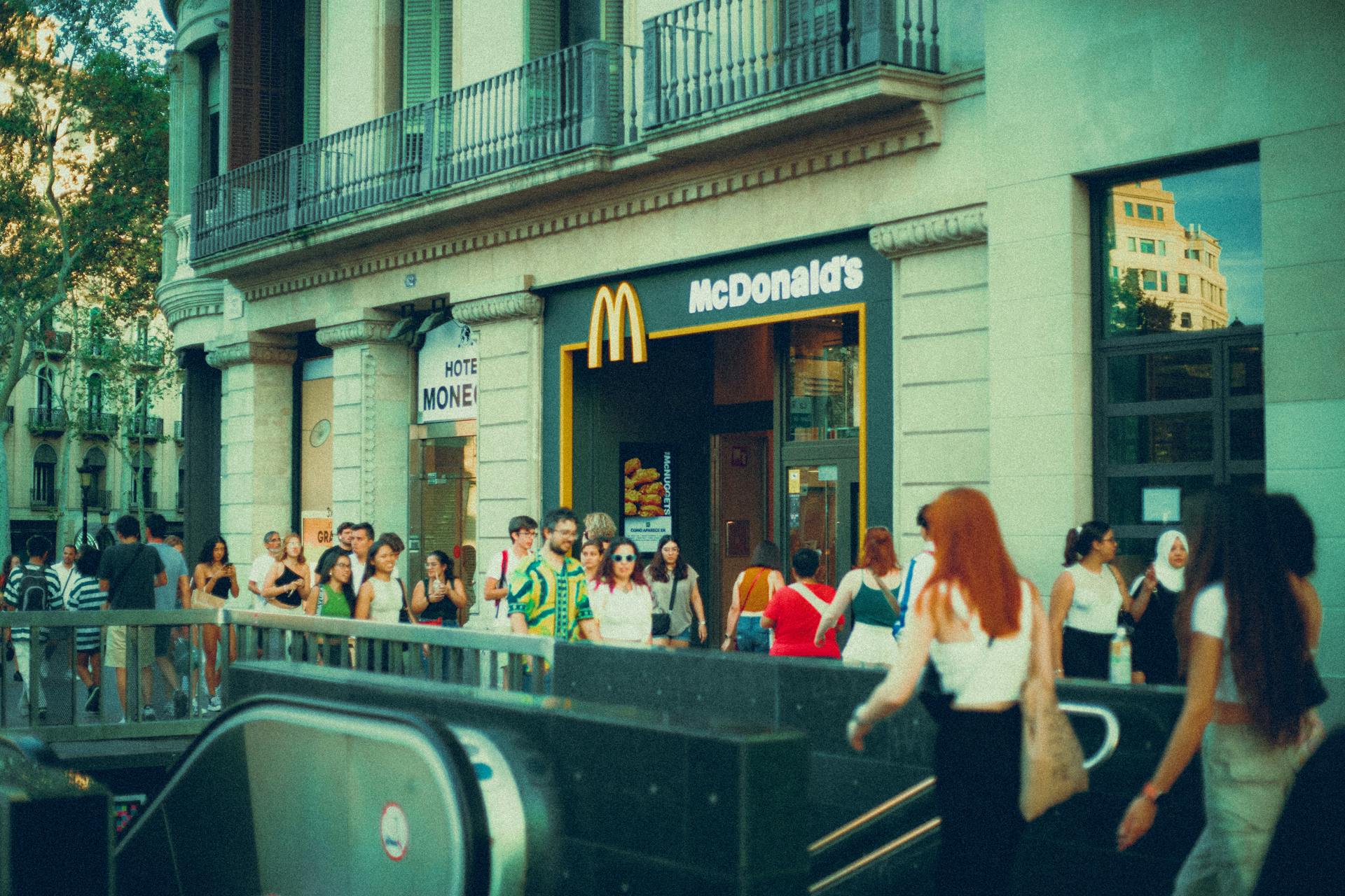 Crowded street scene outside McDonald's with diverse pedestrians.