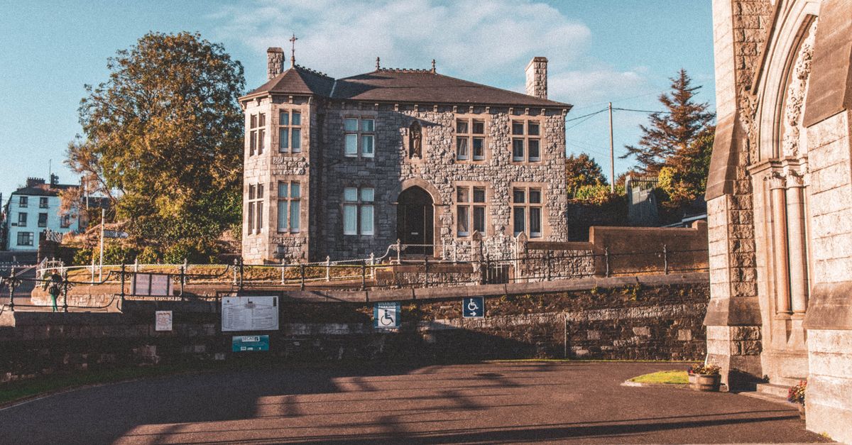 Old stone mansion in the scenic town of Cobh, County Cork, surrounded by historic architecture.