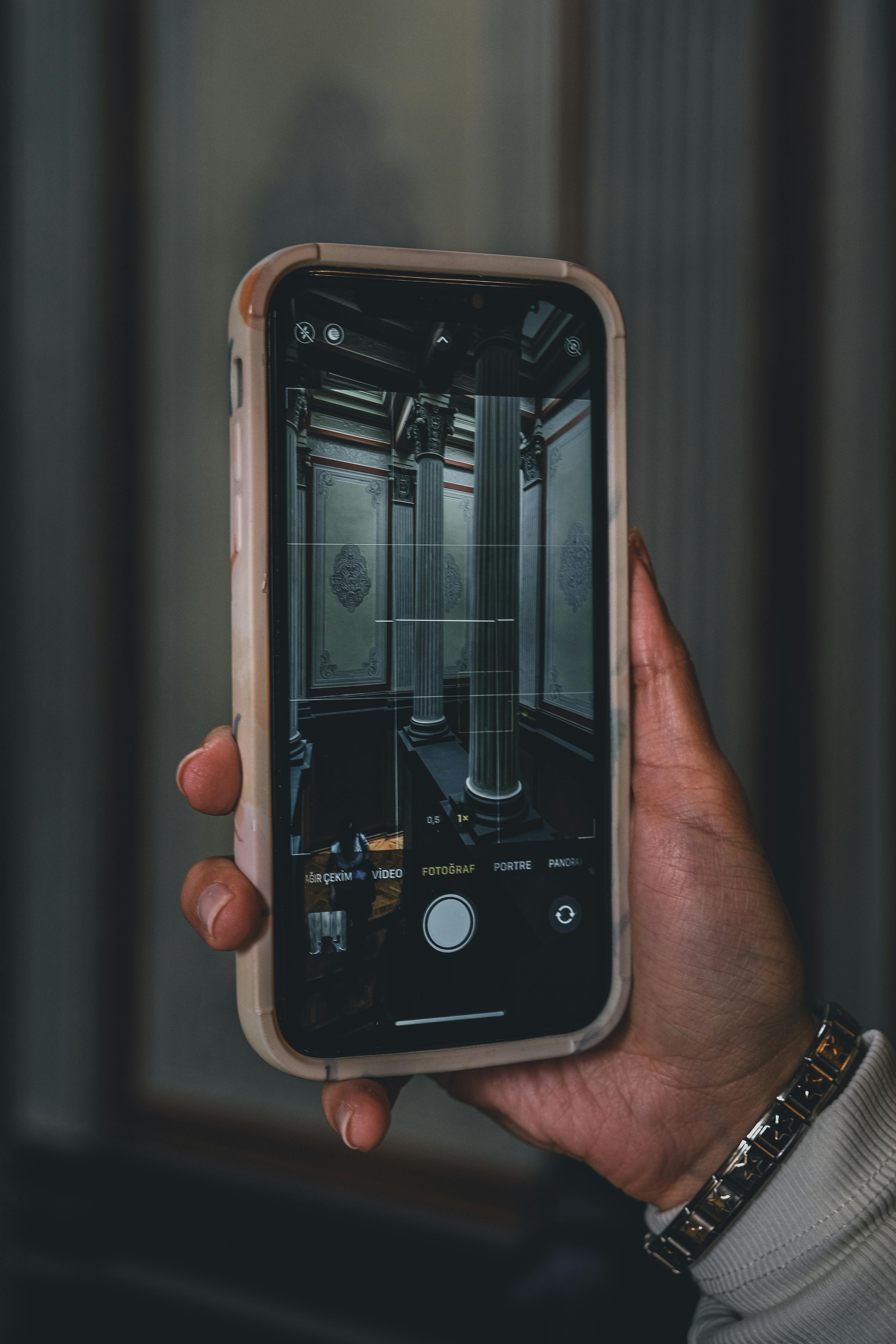 Free Close-up of hand holding smartphone capturing an ornate room interior. Stock Photo