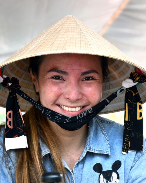 Free A joyful woman wearing a traditional conical hat in Ho Chi Minh City, Vietnam. Stock Photo