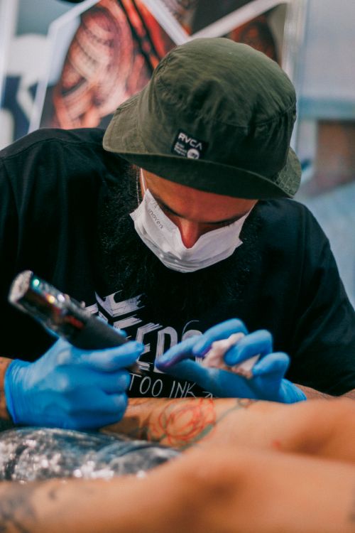 Free A tattoo artist focused on inking a client's arm with precision and care. Stock Photo