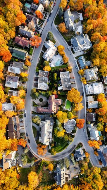 A captivating aerial shot of a neighborhood surrounded by vibrant autumn foliage.
