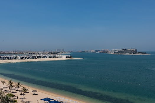 Vista aerea panoramica della costa di Palm Jumeirah a Dubai, Emirati Arabi Uniti, con ville di lusso e acque cristalline.