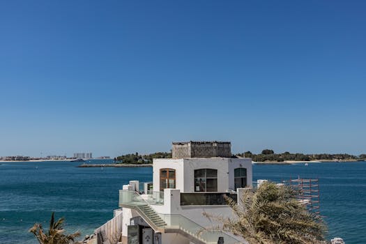 Serene view of a villa by the water on Palm Jumeirah, Dubai, UAE under a clear blue sky.