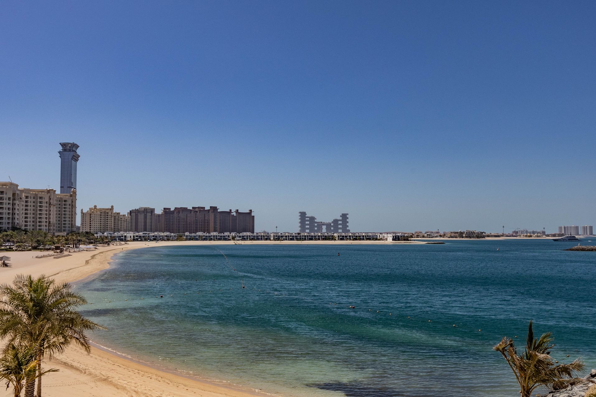 Beautiful beach view at Palm Jumeirah, Dubai with modern skyline and clear blue sea.