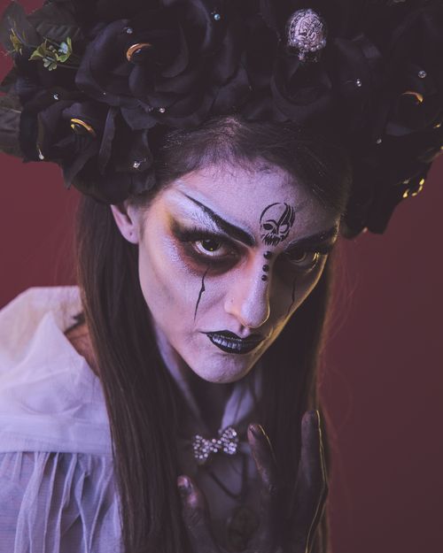 Free Captivating portrait of a woman with Day of the Dead makeup and headdress. Perfect for Halloween themes. Stock Photo