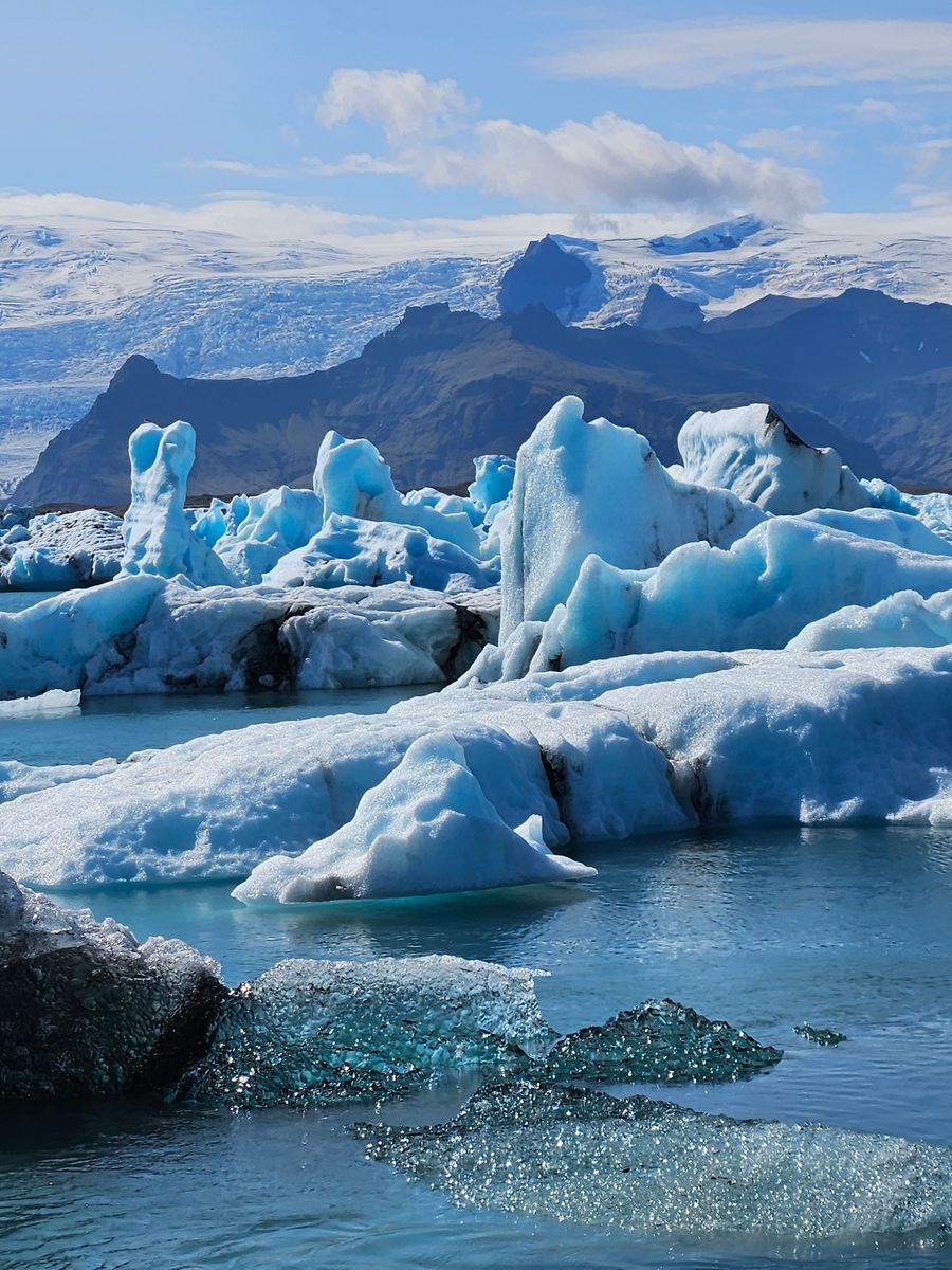 Lagoa glaciar de Jökulsárlón com montanhas ao fundo, Islândia