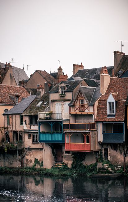 Picturesque riverside medieval houses in France, reflecting on water.