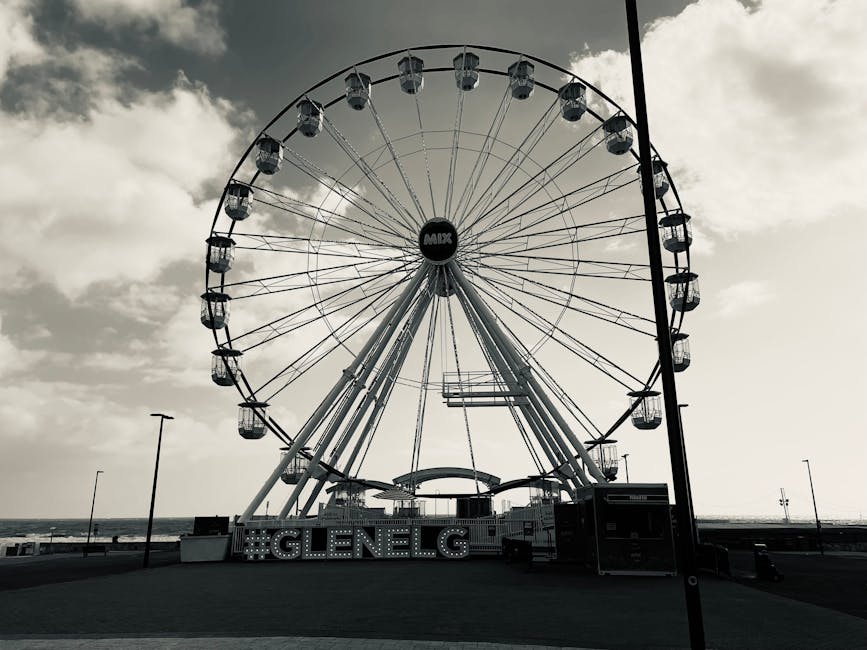 Stunning black and white photo of a Ferris wheel by the sea at Glenelg.