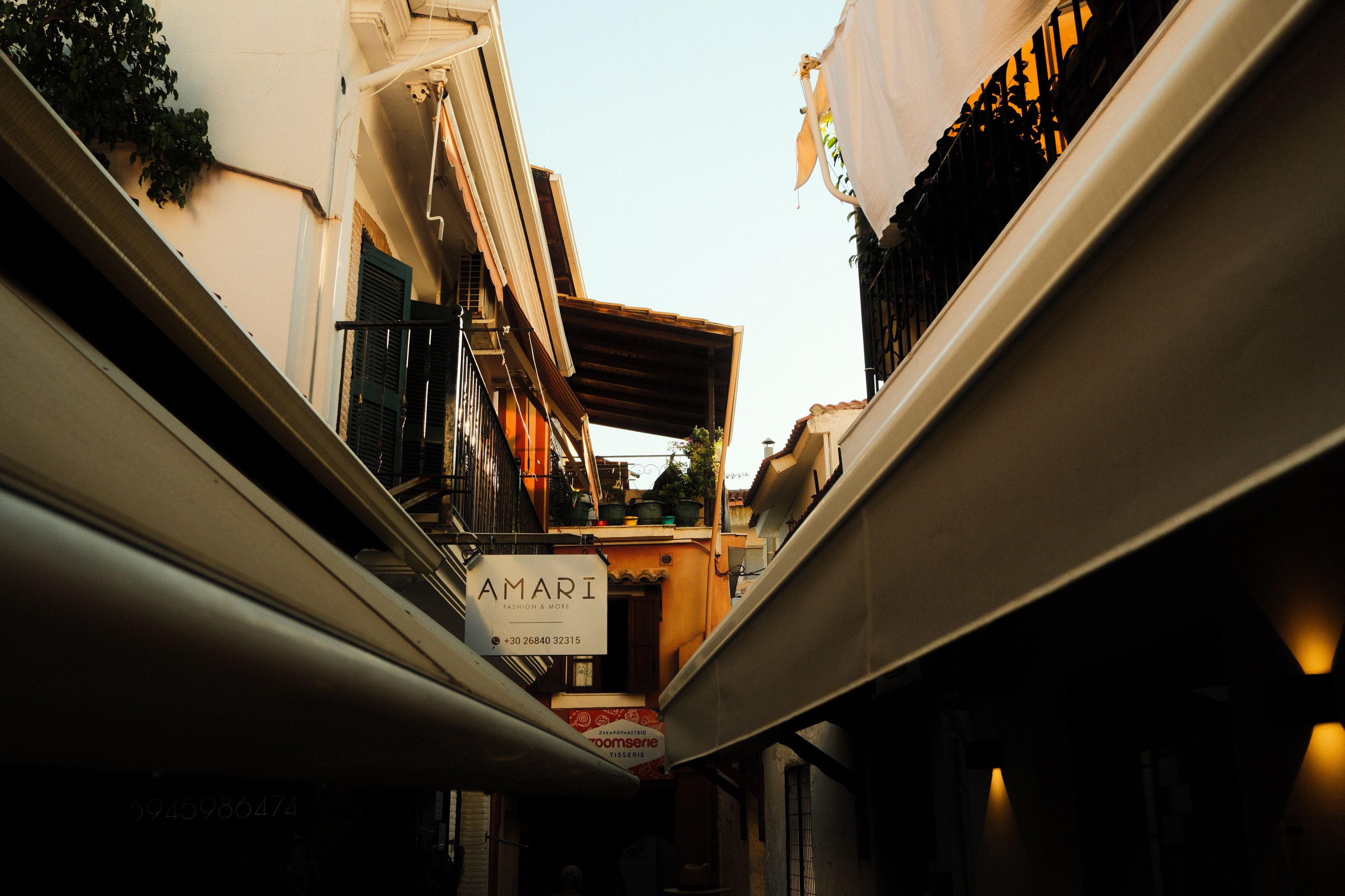 A scenic view of a quaint street in Parga, Greece during sunset, showcasing classic architecture.