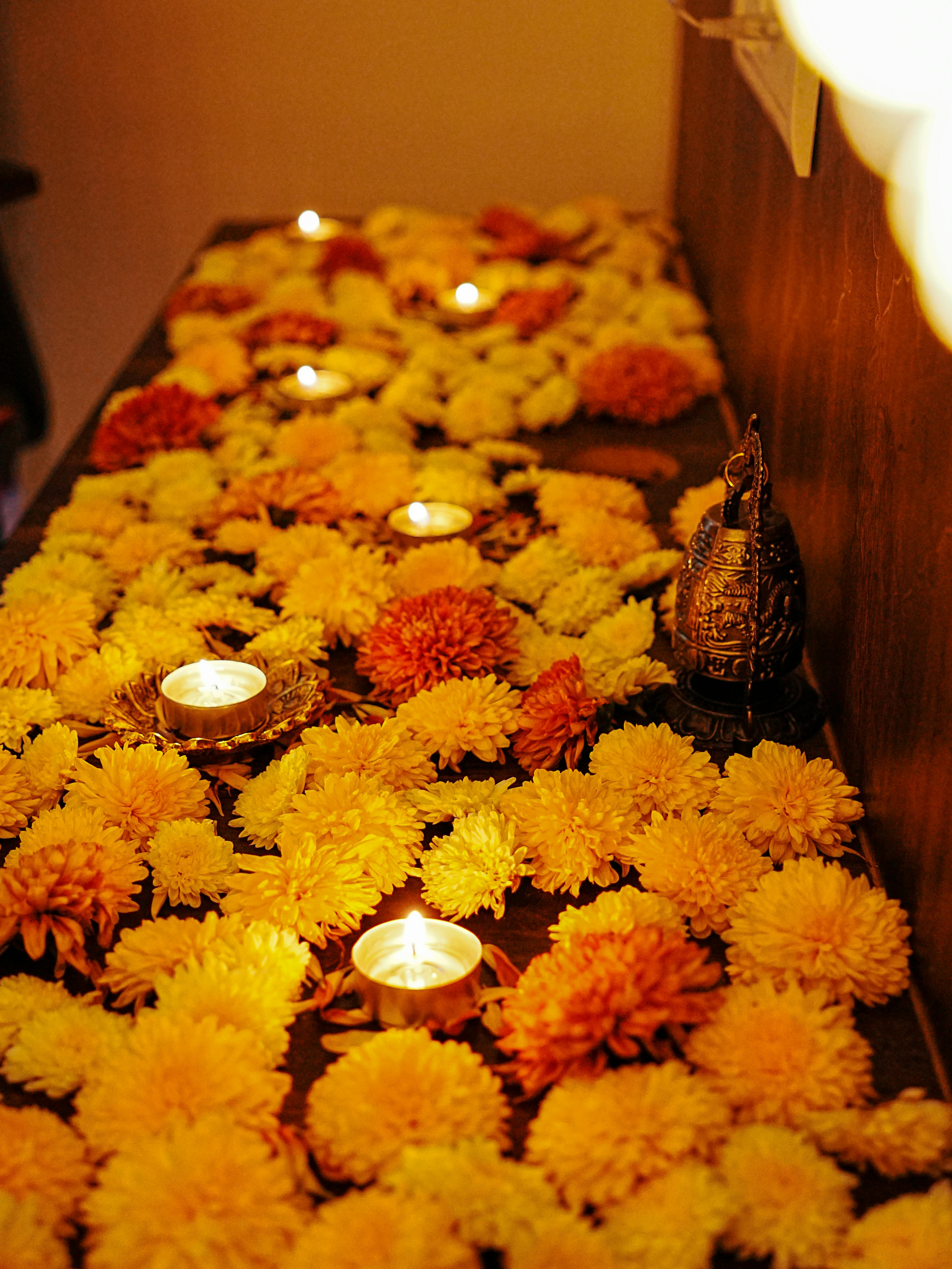 Colorful marigold flowers arranged with candles for a festive decorative setup.