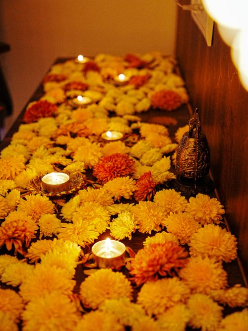 Free Colorful marigold flowers arranged with candles for a festive decorative setup. Stock Photo