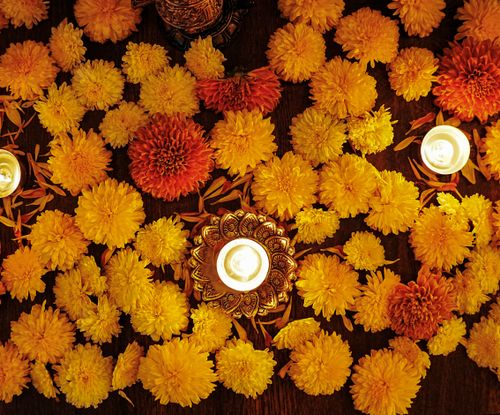 Free Colorful marigold flowers and decorative diyas create a warm festive ambiance for Diwali celebration. Stock Photo