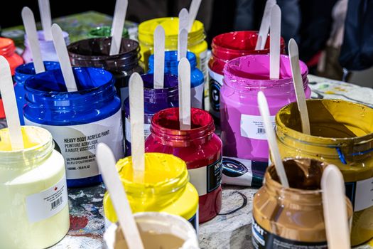 Colorful acrylic paint jars with brushes in Toronto art studio, inspiring creativity.