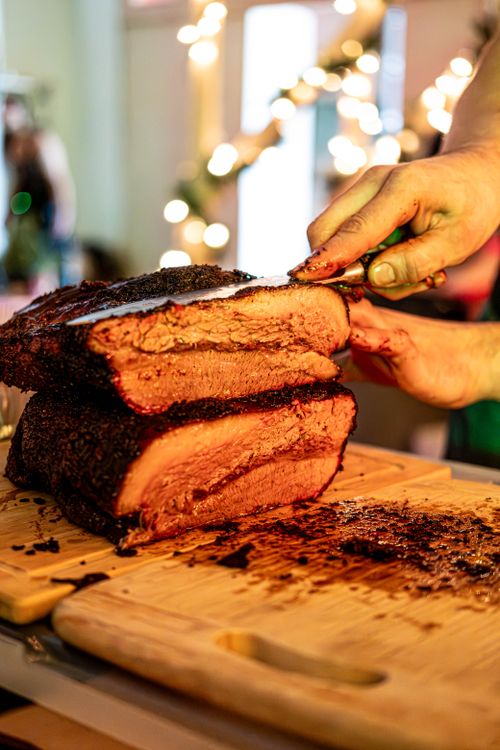 Free Juicy brisket being sliced on a wooden board, perfect for food lovers. Stock Photo