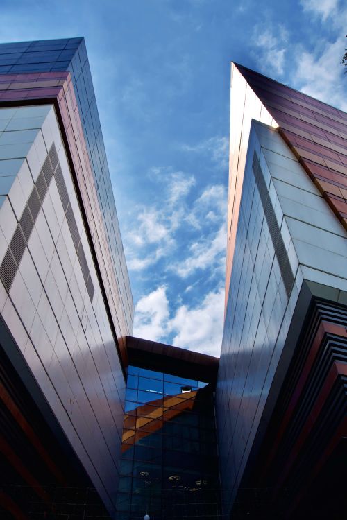 Free Captivating view of modern buildings against a clear blue sky, showcasing geometric architecture. Stock Photo