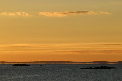 Free Captivating sunrise over Stamfords coast with tranquil sea and golden sky hues. Stock Photo