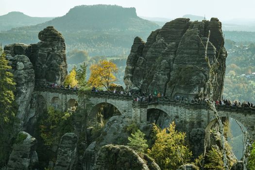 Scenic view of Bastei Bridge surrounded by autumn foliage in Saxony, Germany.