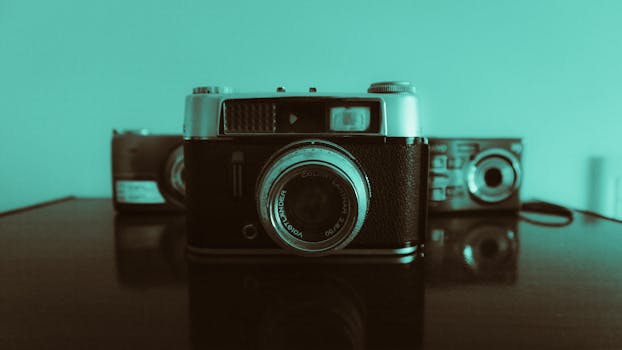 A collection of vintage cameras on a reflective surface with a retro filter, evoking nostalgia.