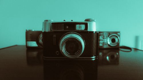 Free A collection of vintage cameras on a reflective surface with a retro filter, evoking nostalgia. Stock Photo