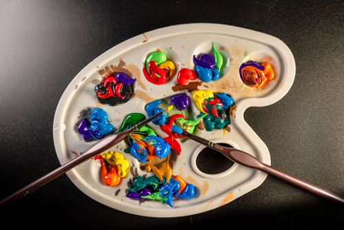 Free Vibrant artist's palette with colorful paint and brushes on a black background. Stock Photo