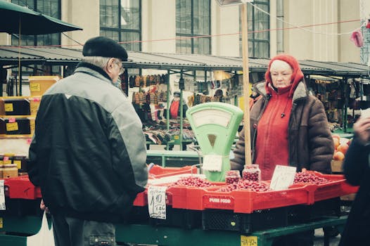 Warm outdoor market scene featuring a vendor and a customer engaging over fresh produce.