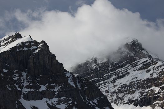 Snow-covered peaks of Jasper National Park in Alberta, Canada, under cloudy sky.