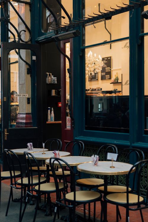 Free Cozy outdoor seating area of a London cafe with elegant decor and chairs. Stock Photo