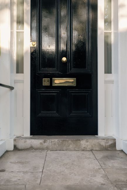 Elegant black front door with brass details on a London townhouse entrance.