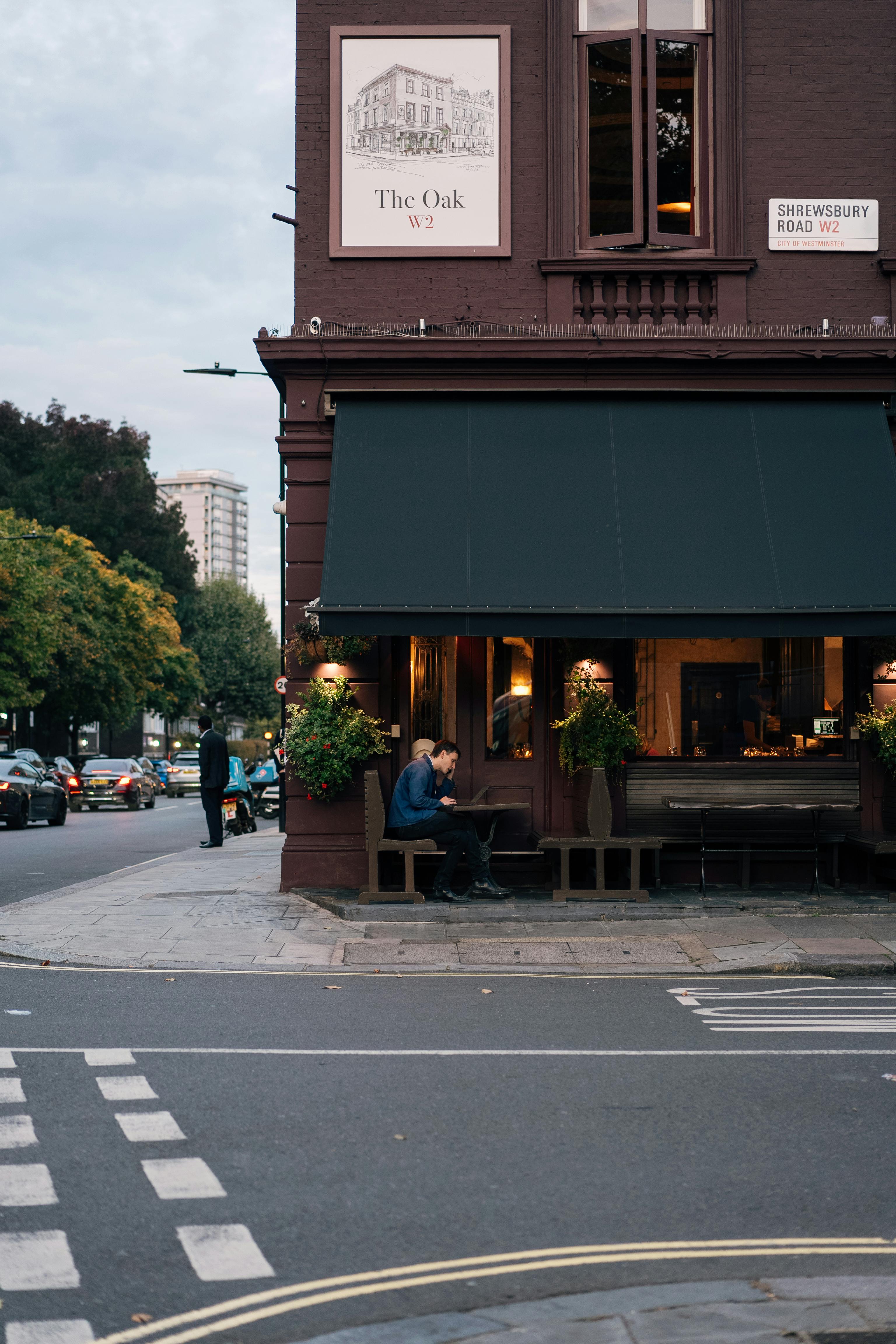 A picturesque view of The Oak café in London with people enjoying a quiet evening.