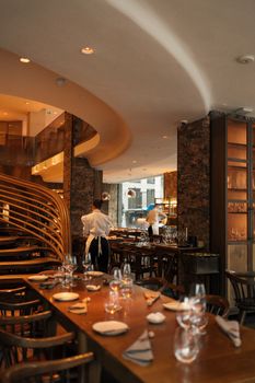 Stylish restaurant interior with patrons and staff in London, UK.