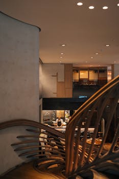 Elegant modern cafe interior in London with unique architectural elements and warm lighting.