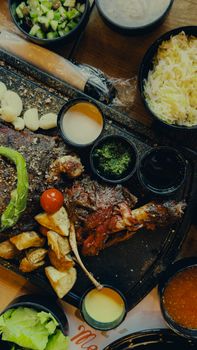 Delicious gourmet steak with sides including grilled vegetables and sauces.