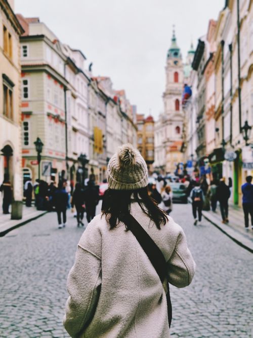 Free Woman in cozy coat exploring the charming streets of Prague's Old Town. Stock Photo