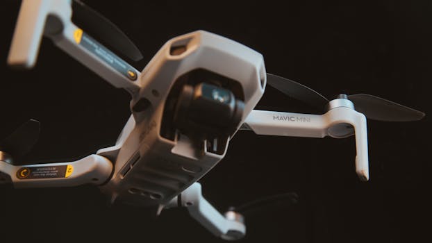 A detailed shot of a DJI Mavic Mini drone hovering mid-air against a dark background.