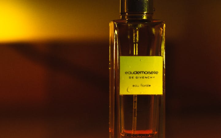 A luxurious perfume bottle elegantly lit with warm colors, symbolizing luxury and fragrance.