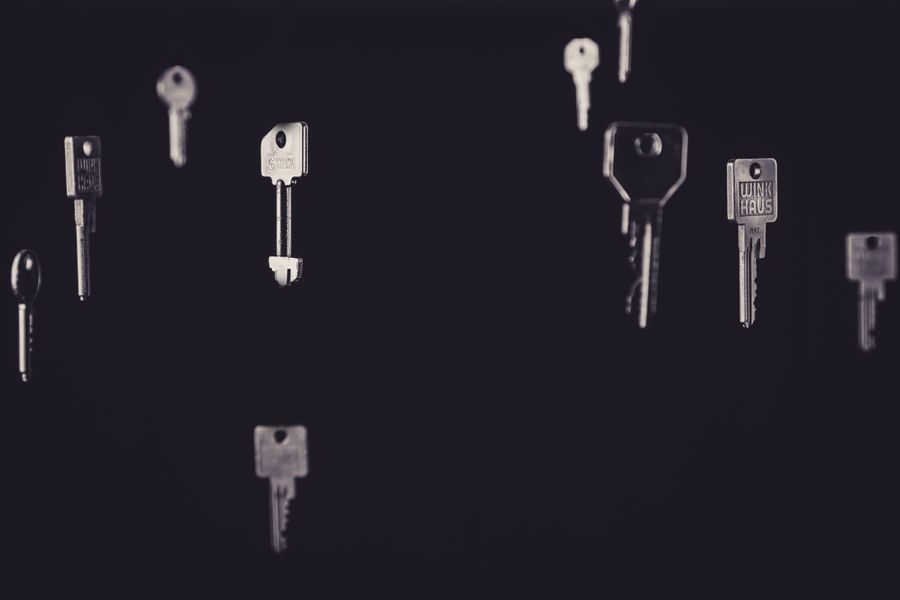 Artistic display of floating metallic keys in a dark, minimalist setting.
