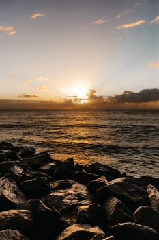 海浪拍打着岩石海岸，海洋上壮丽的日落用温暖的色调渲染了天空