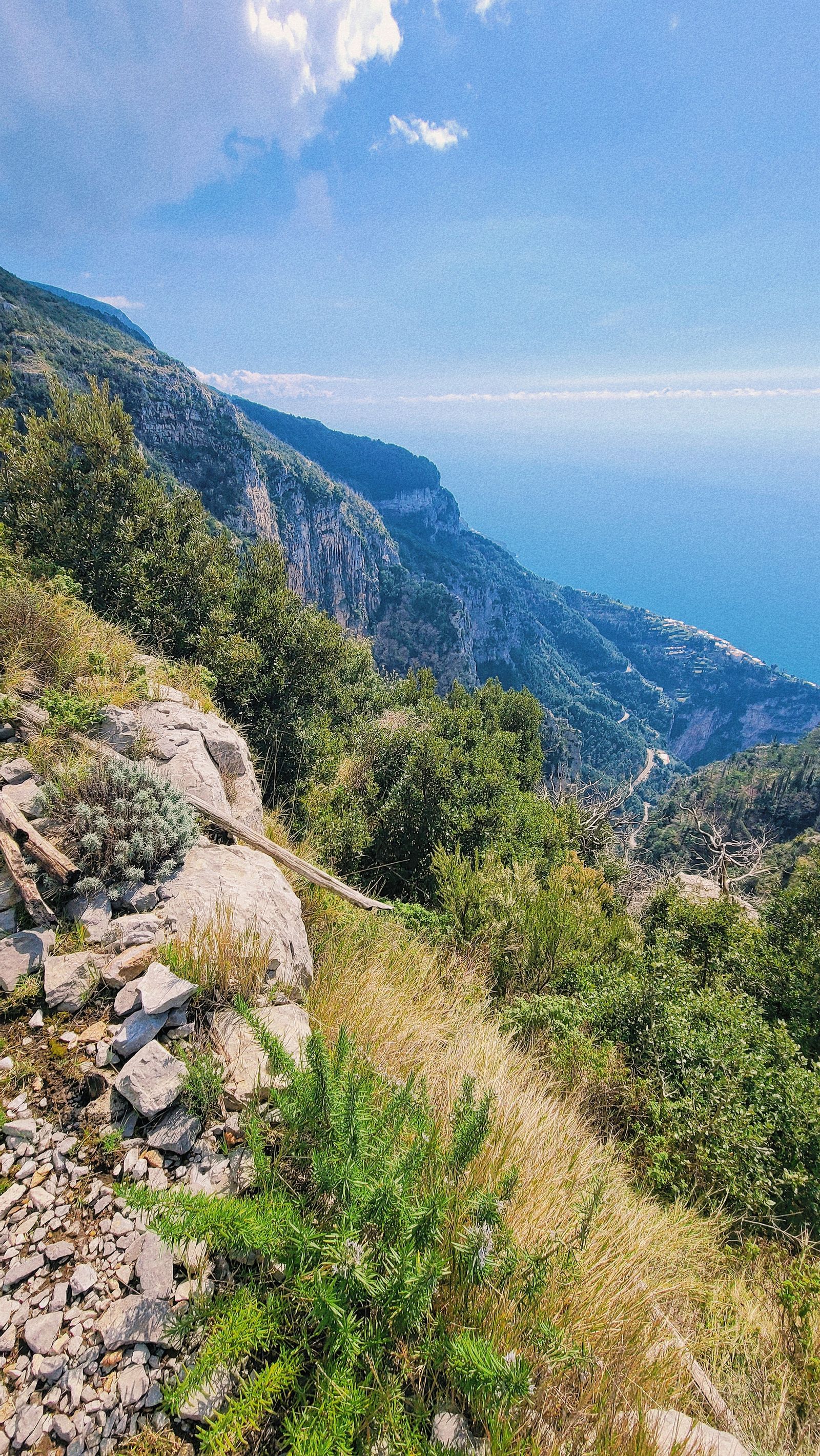 High mountain trail view over steep Amalfi Coast cliffs dropping toward the open sea