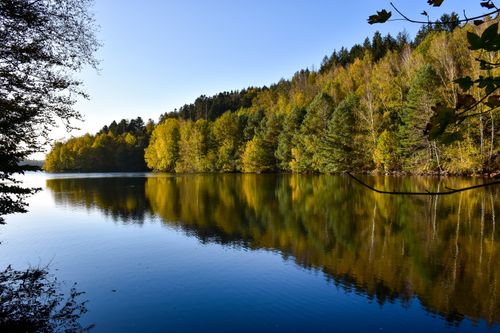 Free Serene autumn landscape of Pierre-Percée Lake, France with vibrant foliage reflections. Stock Photo