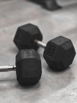 Two hex dumbbells on gym floor, perfect for strength training visuals.